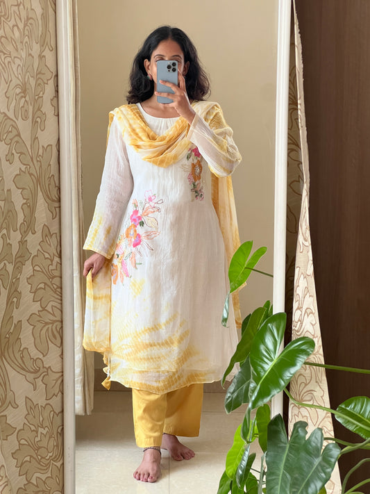 A0502 white & yellow tie dye mul chanderi 3 piece dress with hand paint & embroidery detailing comes with chiffon tie dye duppatta. The best part of this dress is at back part also you have same floral bunch detailing with hand paint & embroidery