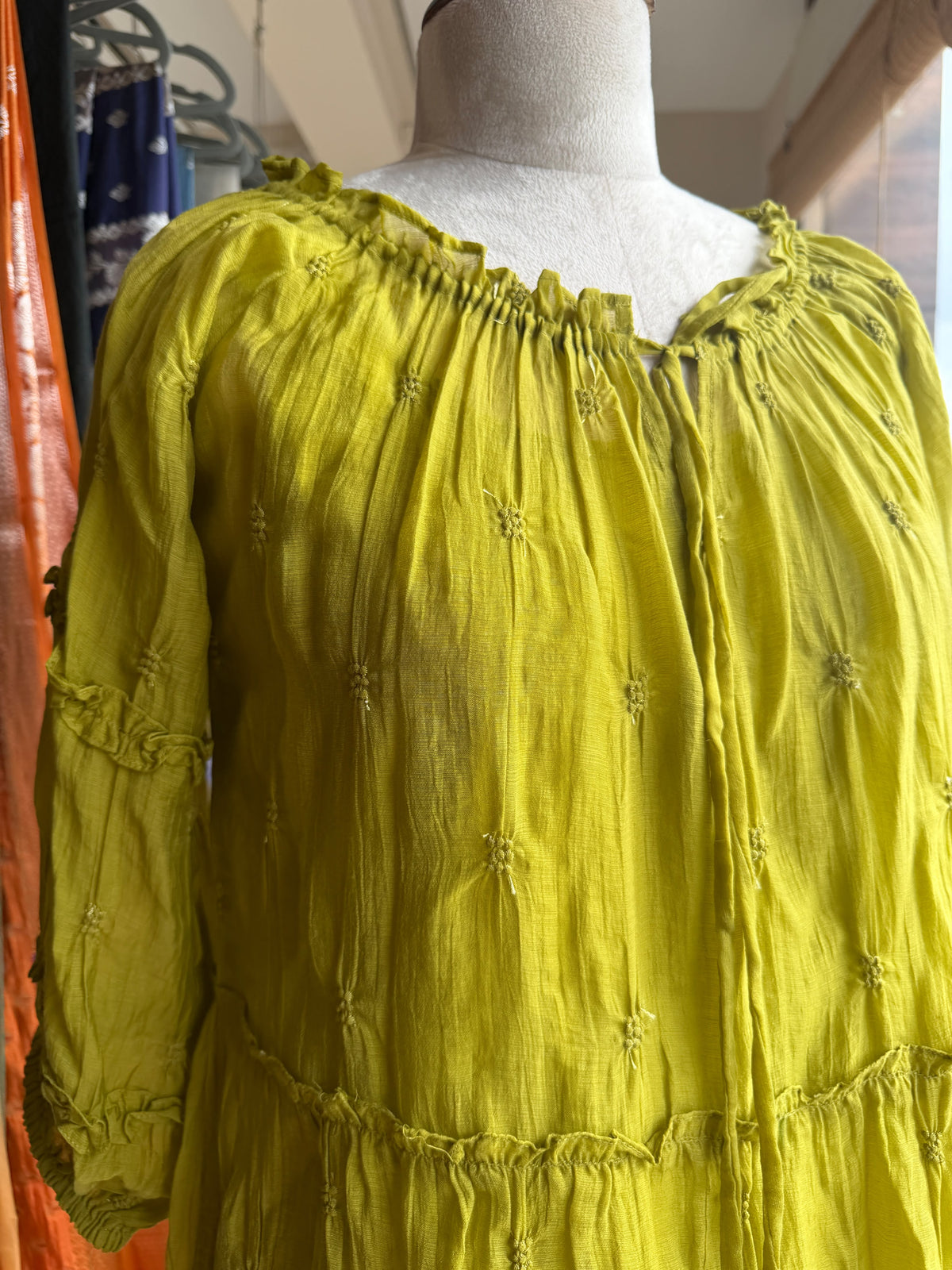Green tier dress with embroidery butties all over the dress